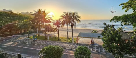 Apartamento | Praia | Na praia, areia branca, guarda-sóis, prática de vôlei de praia