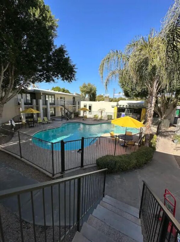Relax by the pool surrounded by a fence and comfortable seating area.