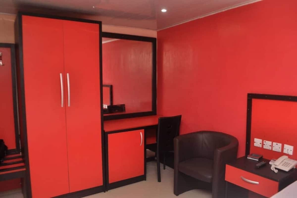 A room with red walls, a desk with a telephone, and a chair.