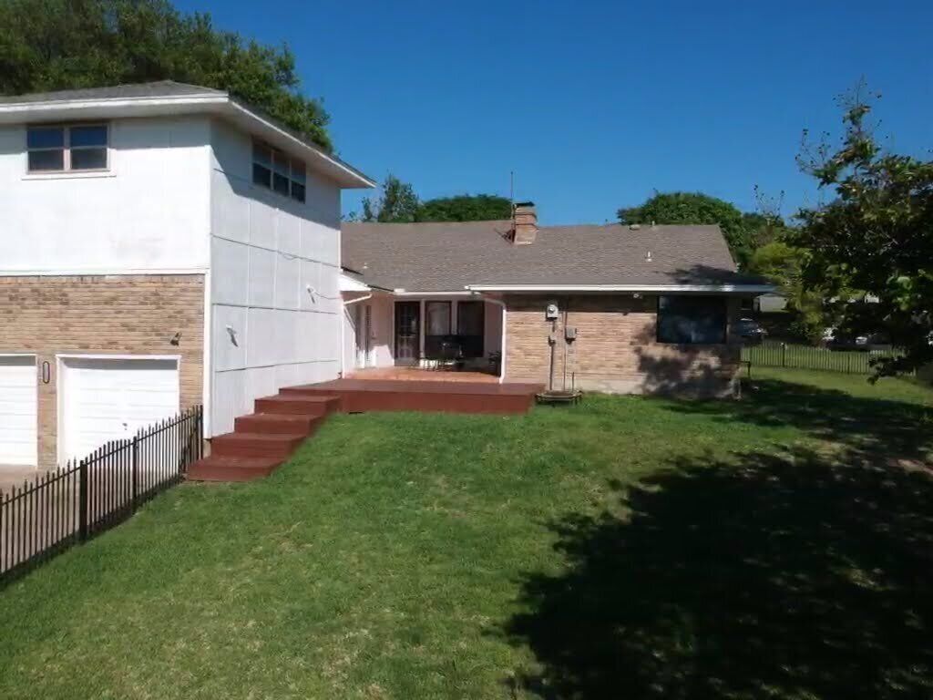 A two-story house with a front porch, a garage, and a well-maintained lawn.