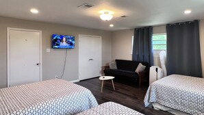 A room with two beds, a television, a sofa, and a small table. - Lake view, Spacious 5 bedrooms, big lot, sleep 18 (Rockwall)
