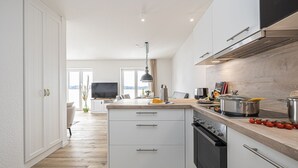 Eine moderne Küche mit einer großen Kochinsel, integriertem Backofen und einem Essbereich mit Blick.
