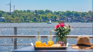 A table with a vase of flowers and orange slices on a boat.