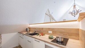 Una cucina moderna con piano di lavoro in legno, lavello in acciaio inossidabile e forno integrato.