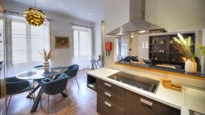 A modern kitchen with a central island, built-in oven, and a large range hood.