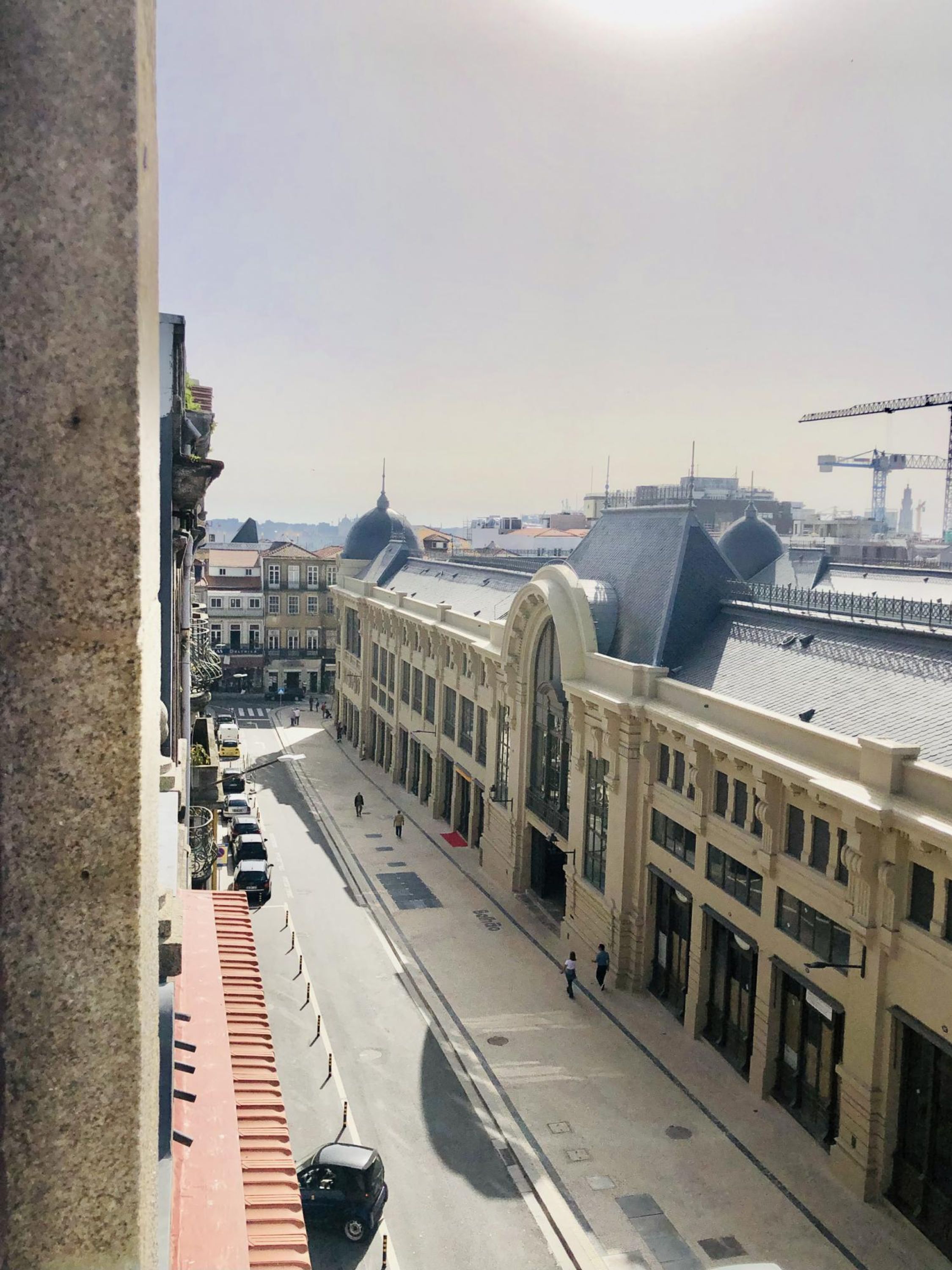 Vista de una calle con un edificio que tiene grandes ventanales y una estructura en forma de cúpula.