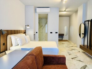 A modern hotel room with a bed, a desk, a chair, a mirror, and a shower area. - Downtown 3A in Oporto (Porto)