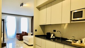 A modern hotel room with a kitchen area, a dining area, and a living space. - Downtown 3A in Oporto (Porto)
