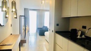 A hotel room with a kitchen area, a dining table, and a bed with a view of the outdoors. - Downtown 2B in Oporto (Porto)
