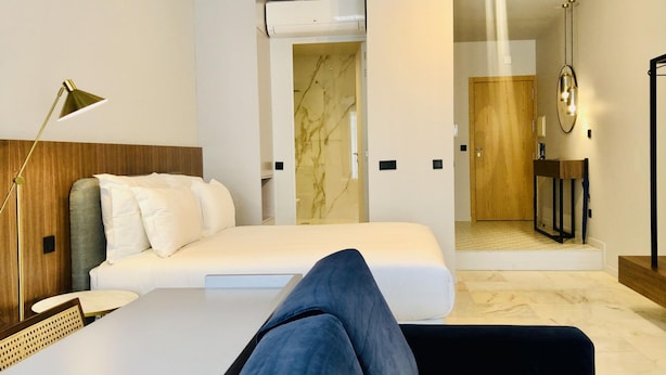 A modern hotel room with a bed, a desk, and a bathroom visible through an open door. - Downtown 2B in Oporto (Porto)