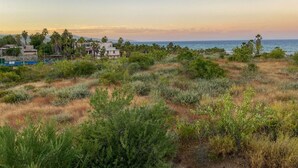Un paisaje costero con edificios, vegetación y vista al mar.