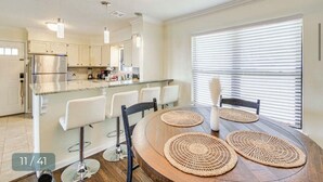 A modern kitchen with white cabinets, a stainless steel refrigerator, and a central island with bar stools. -  Modern Lakefront Property
 (Hot Springs)