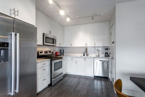 Fully equipped kitchen with refrigerator, oven, microwave, and dishwasher.