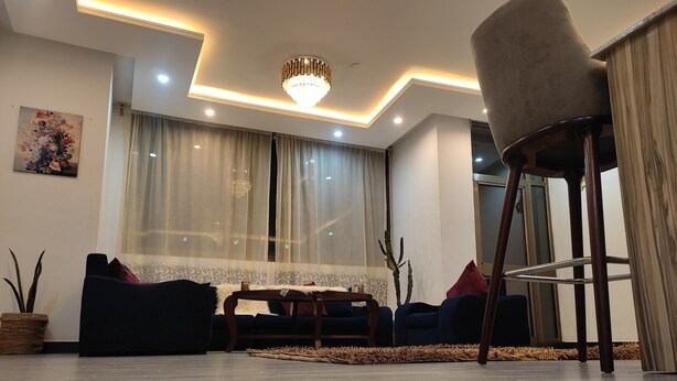 A modern living room with a sofa set, a dining table, and a chandelier. - Addis Hill  (Addis Ababa)