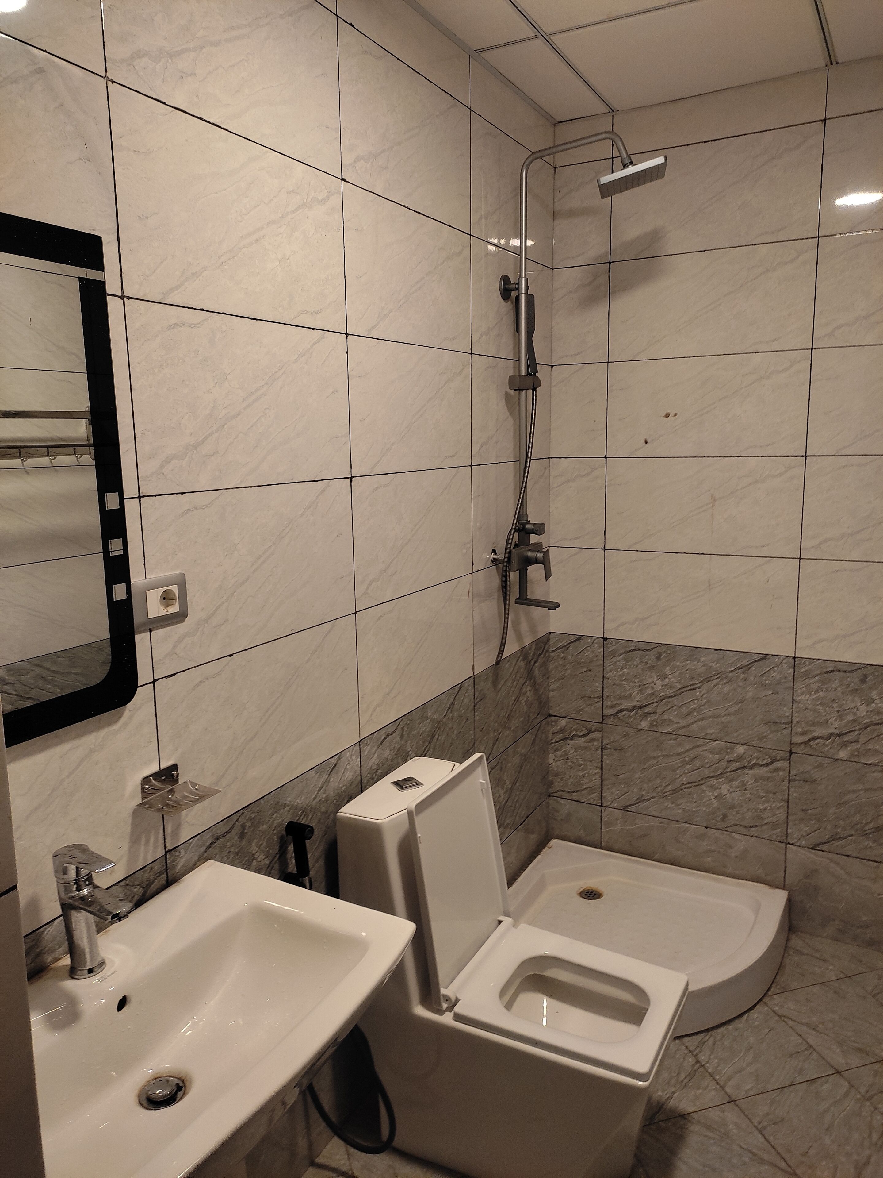 A bathroom with a sink, toilet, and shower.