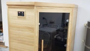 Un sauna doté d’un panneau de commande et d’une porte en verre.