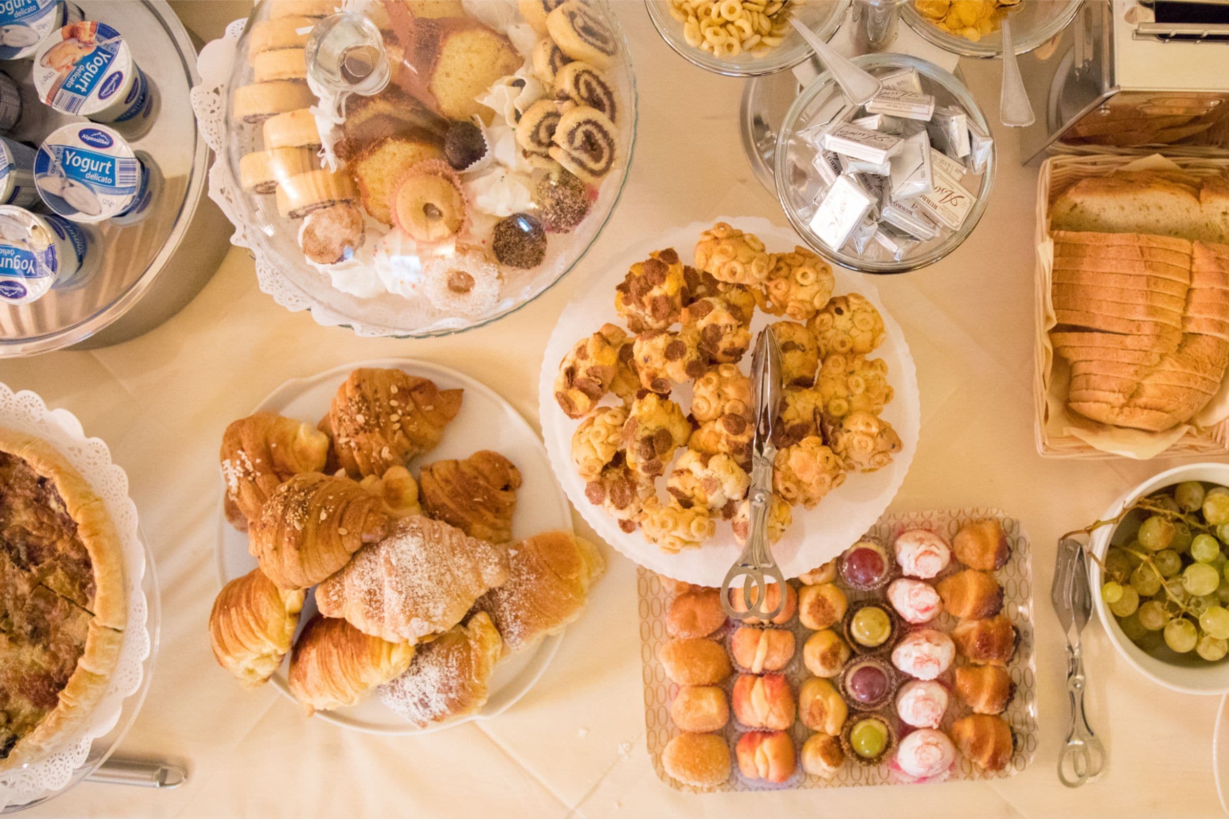 Un buffet con diverse pietanze, tra cui pasticcini, frutta e salse.