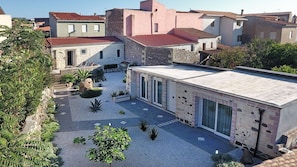 Un cortile con un edificio moderno, caratterizzato da ampie finestre e una facciata in pietra.