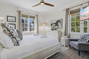 A bedroom with a large bed, a desk, a chair, and a ceiling fan. - Walk to Beaches, Dining & Everything Coronado Has to Offer  |  Coronado Crown Vi (Coronado)