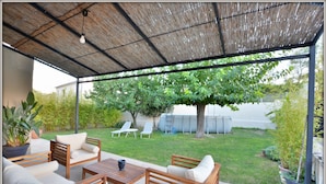 Une terrasse extérieure avec des meubles en bois, une table et une plante en pot.