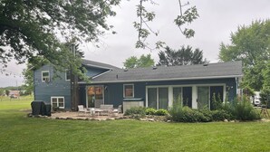 A two-story house with a covered patio, a garage, and a lawn. - Remodeled Modern 4BR Avon Home with 3 Living Rooms on Large Private Lot/Farm (Avon)