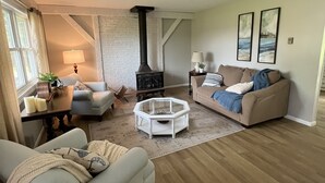 A living room with a fireplace, two couches, a coffee table, and a rug. - Remodeled Modern 4BR Avon Home with 3 Living Rooms on Large Private Lot/Farm (Avon)