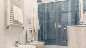 A modern bathroom with a glass shower enclosure, two sinks, and a towel rack. - Casina Rossa (Naples)