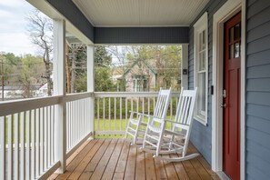 A porch with white rocking chairs and a red door. - NEW! UPTOWN Cottages - 2bed/1bath-new furnishings! (Hot Springs)