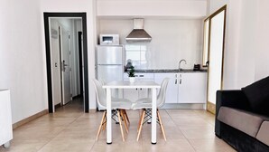 A modern kitchen with white cabinets, a microwave, and a stainless steel range hood. - New Trebol (Benidorm)