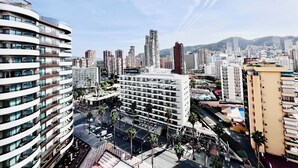 A modern urban hotel with multiple floors, a central courtyard, and a view of the cityscape. - New Trebol (Benidorm)