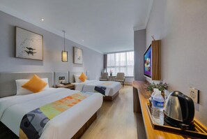 A hotel room with two beds, a desk with a kettle, a TV, and artwork on the walls. - Shell Zhengzhou Zhongyuan Fota Hotel (Zhengzhou)