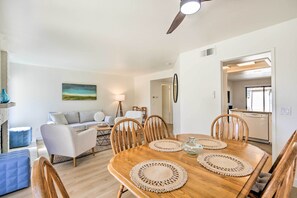 A dining area with a wooden table, four chairs, and two woven placemats. - Extended Stay Near Beach! Carlsbad Condo w/ Pool (Carlsbad)