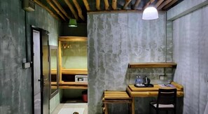 A compact room with a wooden desk, chair, and a small shelf. A door leads to another room. - OYO 89411 900 Inn (Bintulu)