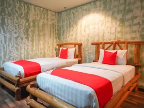 Two wooden beds with red and white bedding, set against a textured green wall. - OYO 89411 900 Inn (Bintulu)