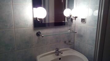 A bathroom with a white sink, a mirror, and two wall-mounted lights.