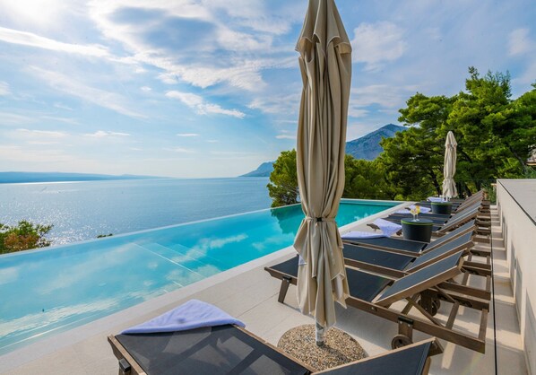 An infinity pool, a heated pool, sun loungers