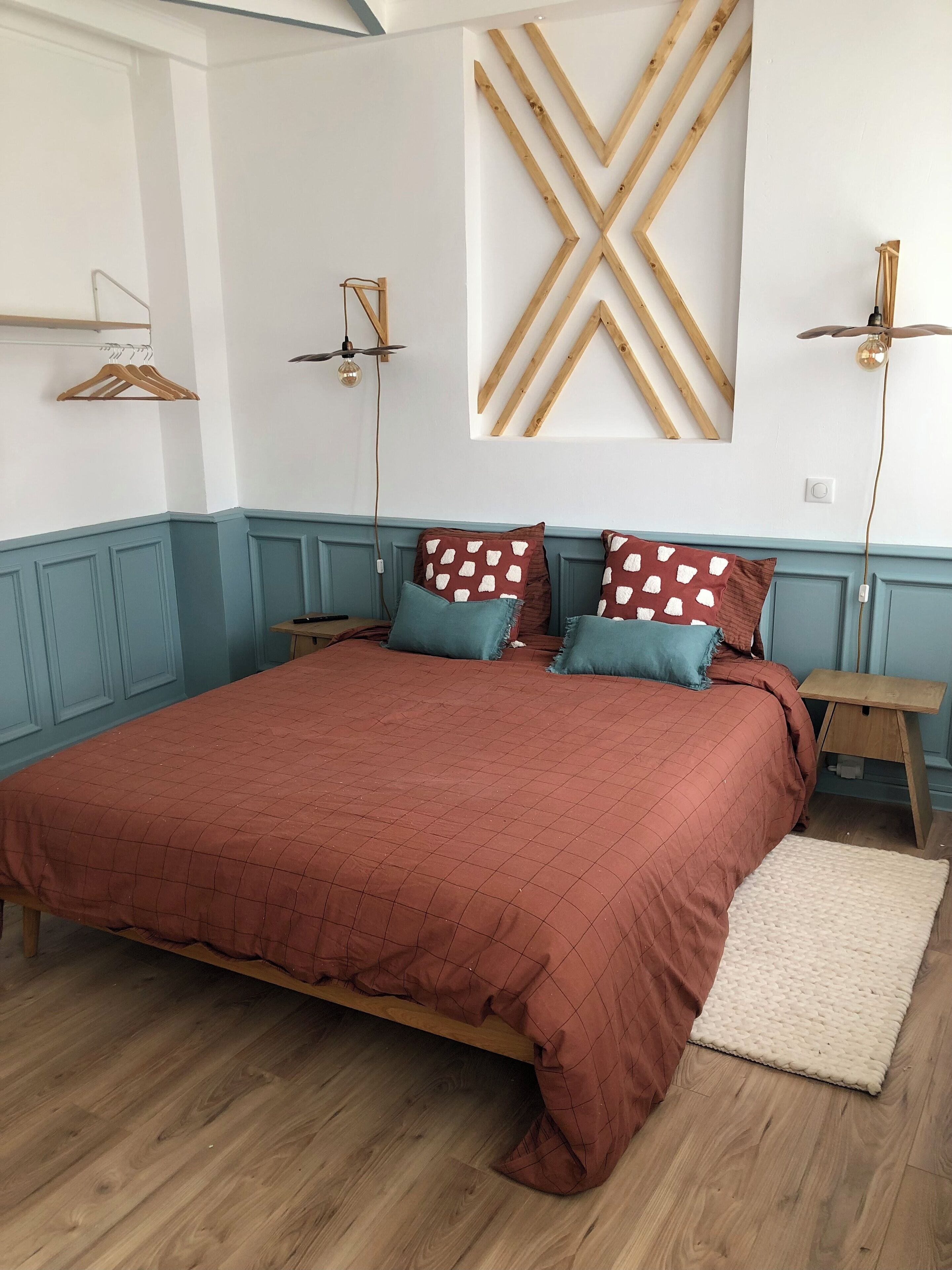 Ein Schlafzimmer mit einem gro ßen Bett, einem Holz-Kopfteil, zwei Nachttischen, einem Deckenventilator und einer wandmontierten Leuchte.