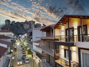 A street view with buildings, cars, and a mountainous backdrop. - Centro Urban Suites (Kalabaka)