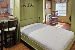 Compact room with a bed, desk, and chair, perfect for work or leisure.