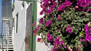 Un edificio bianco con una porta verde e un balcone con scarpe.