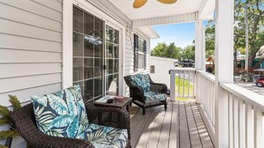 Eine überdachte Veranda mit Korbmöbeln und Deckenventilator.