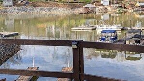 Un lago tranquillo con barche ormeggiate e un pontile di legno in primo piano.