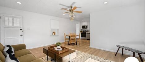 A modern living room with a sofa, coffee table, and a ceiling fan.