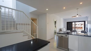 A modern kitchen with a black countertop, stainless steel dishwasher, and white cabinets. - Apartamento Calma (Mar de Pulpi) (San Juan de los terreros)