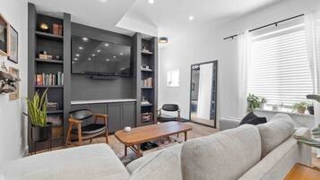 Smart TV, caminetto, libri, impianto stereo