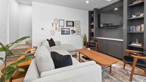 Un salon moderne avec un canapé, une table basse et une bibliothèque.