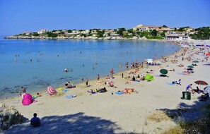 A beach with people swimming and sunbathing, a clear sky, and buildings in the background. - Amazing home in Martigues (Martigues)