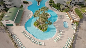 Ein Pool mit mehreren Bereichen, umgeben von Liegestühlen und Palmen.