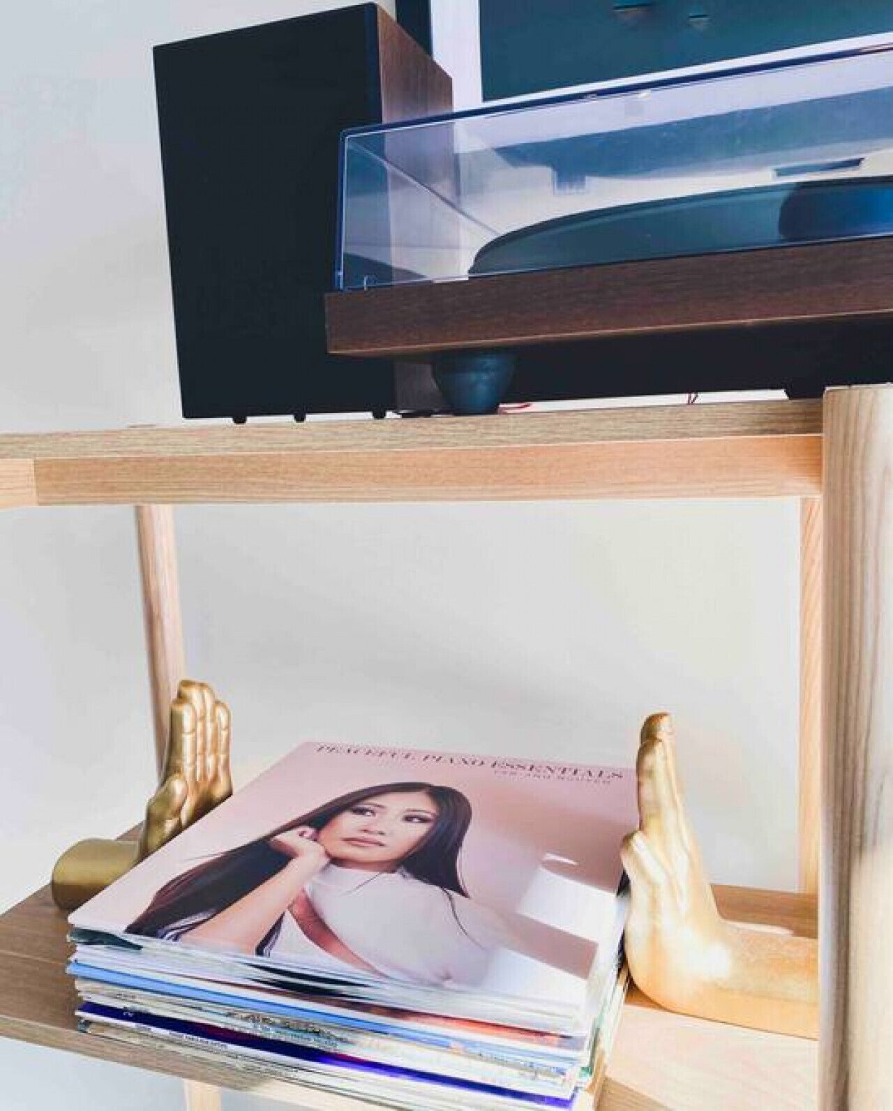 A shelf with a stack of magazines and a clear plastic container.