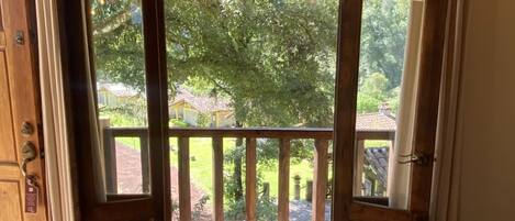 A wooden-framed room with a large window and a view of a garden.